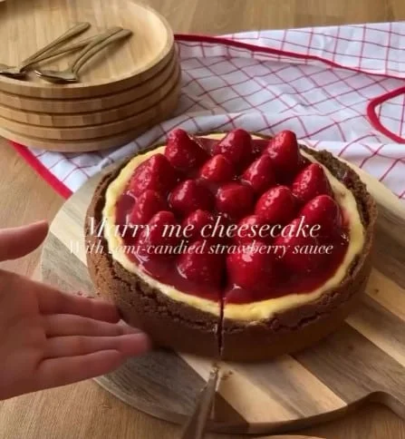 Marry Me Strawberry Cheesecake with strawberry sauce on a wooden board
