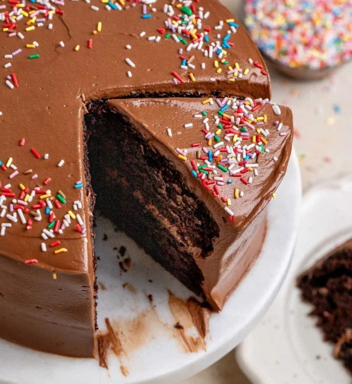 Close-up of a mini chocolate cake slice with sprinkles on top, showing rich layers