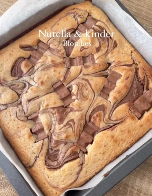 Close-up of a rich, freshly-baked blondie square, with swirls of hazelnut spread and chocolate pieces melting in
